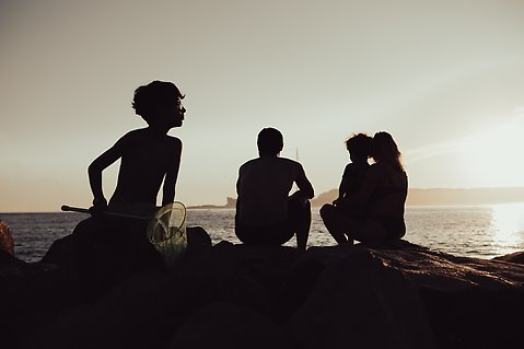 Bild på familj nere vid en strand.